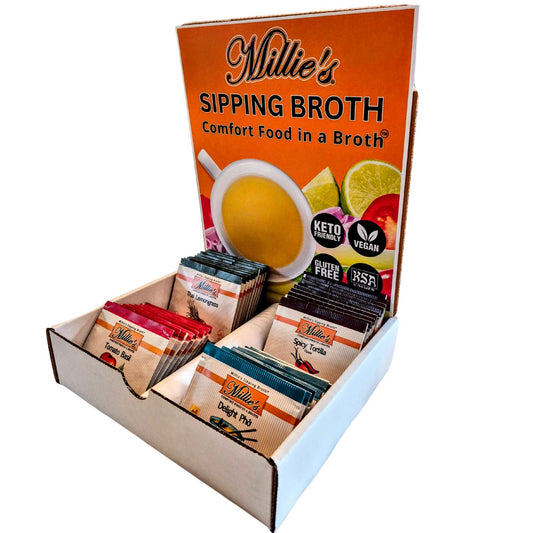 A variety pack of Millie's Sipping Broth soup bags in an open box, displaying four flavors: Thai Lemongrass, Spicy Tortilla, Tomato Basil, and Delight Pho.
